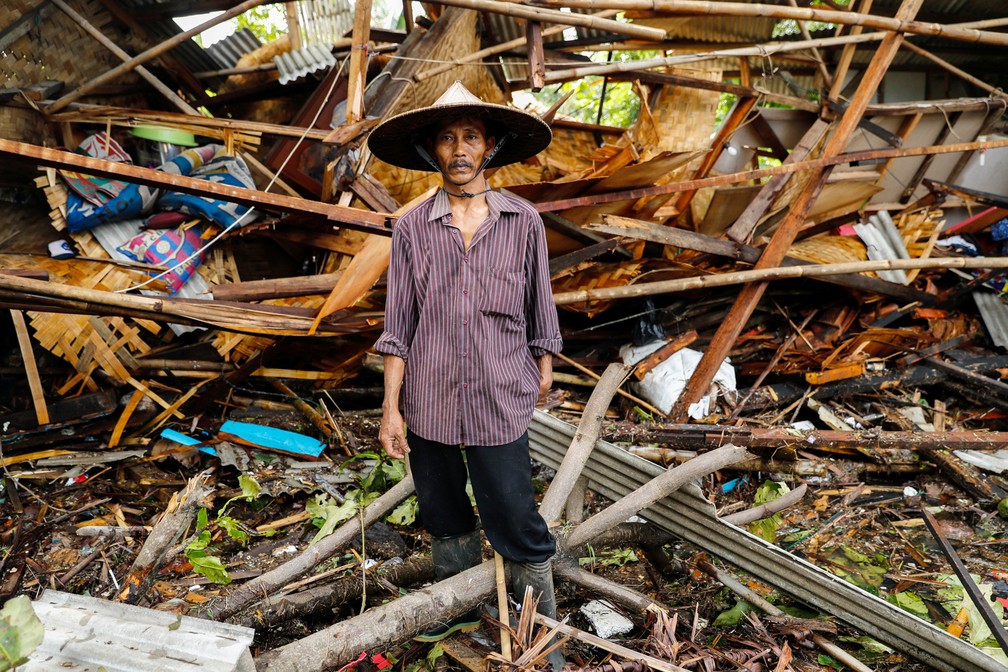24 de dezembro â Um homem posa para foto na frente de sua casa destruÃ­da apÃ³s ser atingida por um tsunami em Pandeglang, na provÃ­ncia de Banten, na IndonÃ©sia â Foto: Jorge Silva/Reuters
