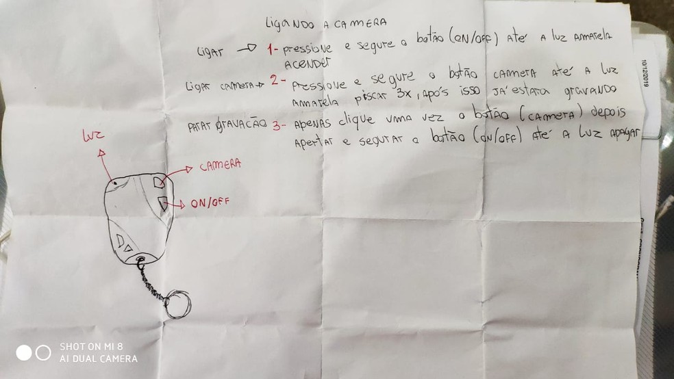 Agentes também encontraram um papel com instruções de como ligar, gravar e desligar a câmera espiã — Foto: TV Centro América/Reprodução
