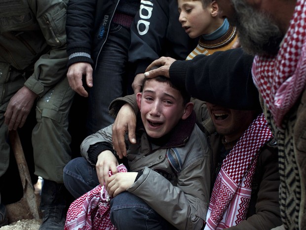 Ahmed chora a morte do pai Abdulaziz Abu Ahmed Khrer, que foi morto por um franco-atirador do Exército sírio em Idlib, ao norte da Síria. (Foto: Rodrigo Abd/AP)