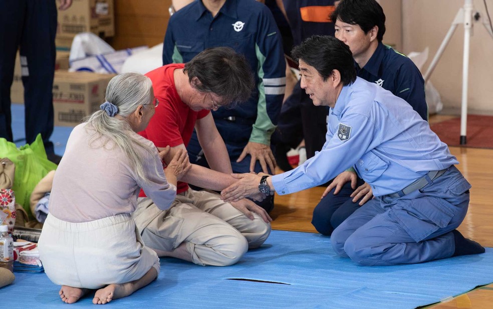 O primeiro-ministro do Japão, Shinzo Abe, visita um abrigo para as pessoas afetadas pelas recentes inundações em Mabi, província de Okayama (Foto: Martin Bureau / AFP Photo)