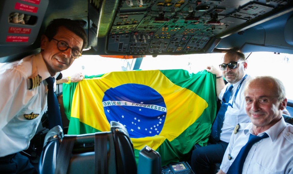Tripulação do Beluga segurando a bandeira brasileira — Foto: Reprodução/Facebook Airbus
