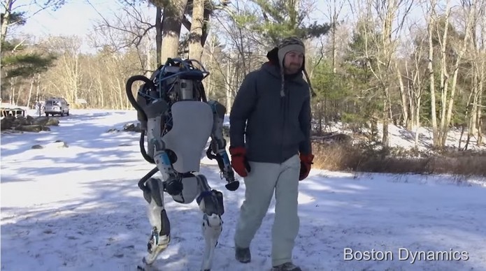 Robô caminha na neve ao lado de humano (Foto: Divulgação/Boston Dynamics)
