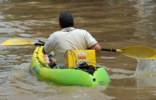 Em janeiro de 2011, um morador de Rockhampton, cidade afetada por inundações na Austrália, foi flagrado usando um caiaque para ir buscar cerveja (Foto: Torsten Blackwood/AFP)