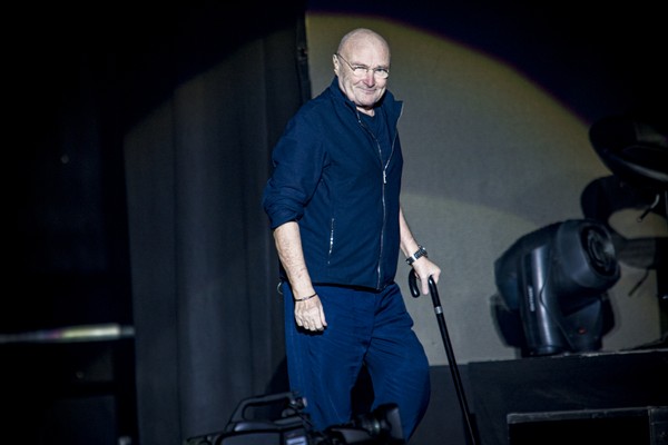 O cantor Phil Collins caminhando de bengala durante um show (Foto: Getty Images)