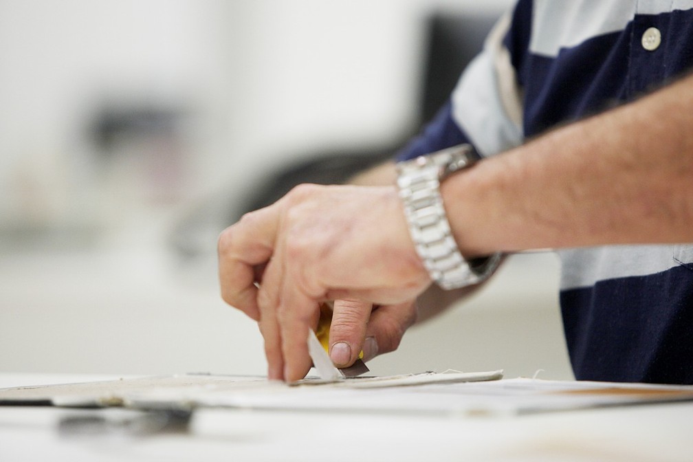 William está aprimorando técnicas de restauração de livros na universidade — Foto: Aline Jasper/UEPG