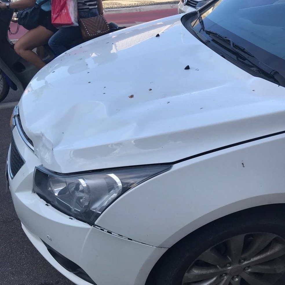 Polícia registrou danos no retrovisor e no capô do carro  — Foto: PM/ Divulgação