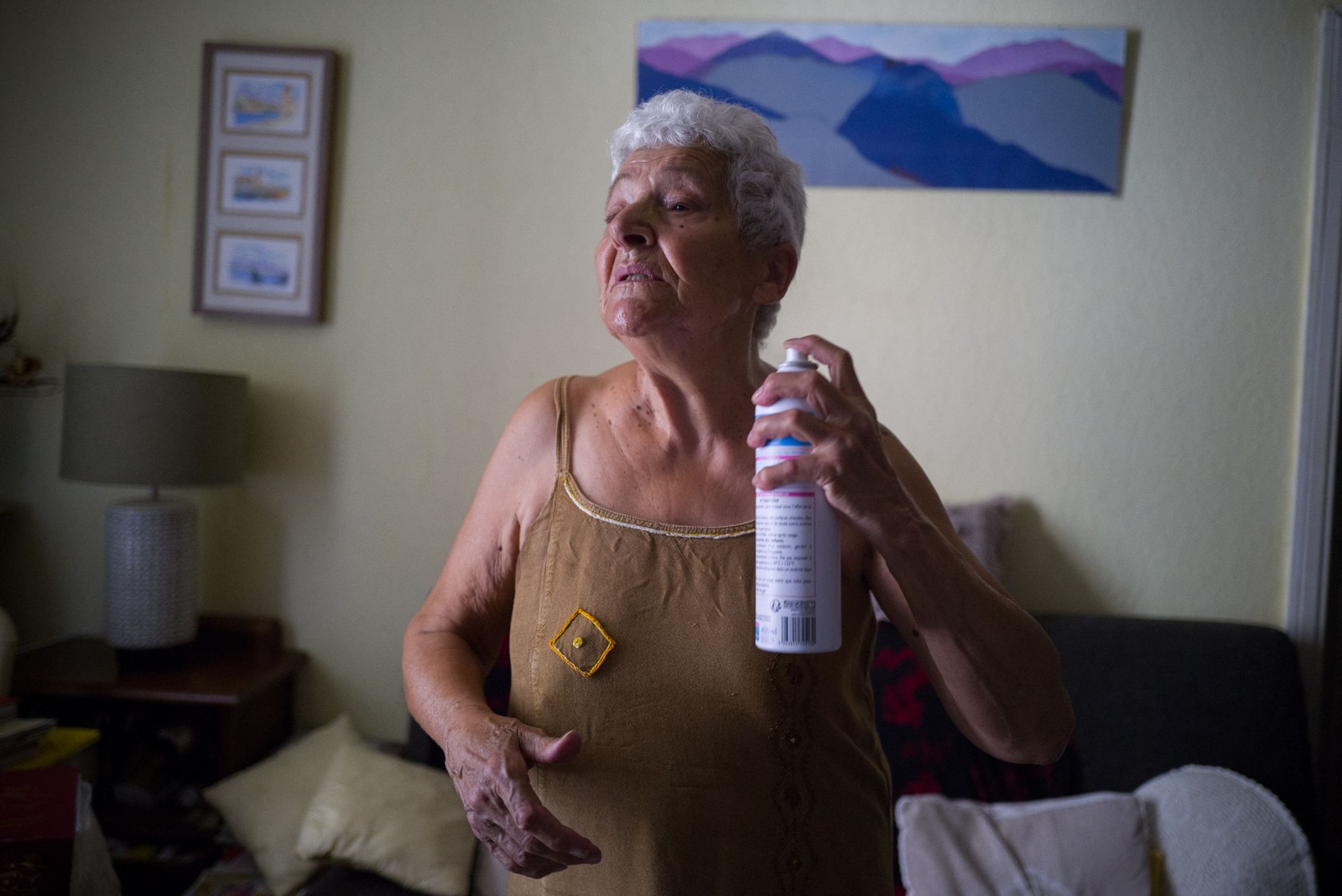 Jackye Lafon, uma aposentada de 81 anos, se refresca com um spray de água em seu apartamento na Cité Bourbaki, no distrito de Minimes, em Toulouse, França  — Foto: FRED SCHEIBER / AFP