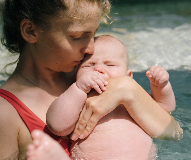Foto ilustrativa mostra mãe brincando com bebê na piscina (Foto: Pexels)