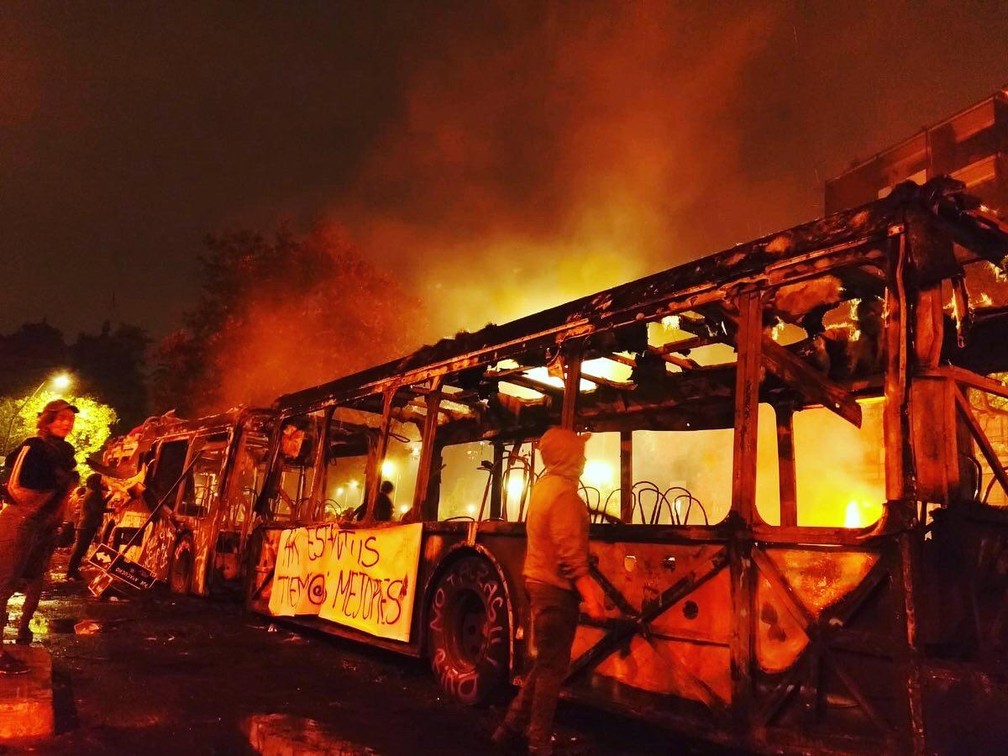 Ônibus incendiado no bairro de Bellas Artes, em Santiago, na noite de sábado (19) — Foto: Adriane Schultz/G1
