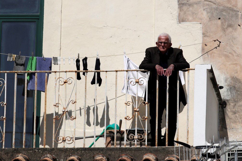 Um homem é visto na varanda durante isolamento em Amalfi, na Itália, durante isolamento do país para evitar a propagação do novo coronavírus  — Foto:  Ciro De Luca/Reuters
