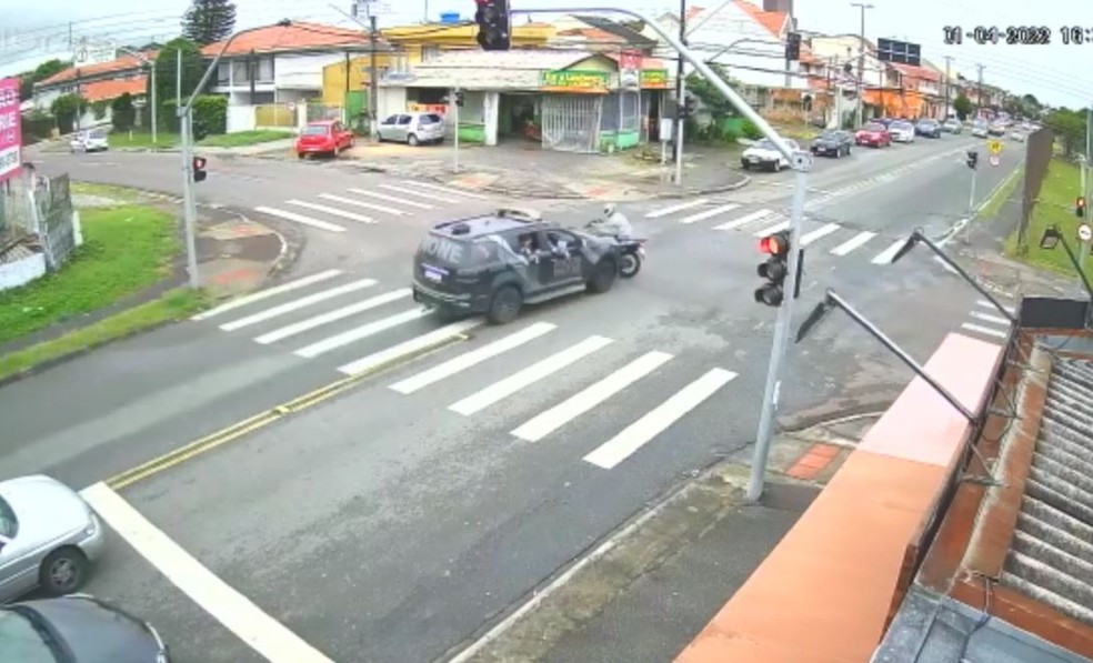 Vídeo mostra carro da PM furando sinal vermelho pela contramão e acertando motociclista, em Curitiba — Foto: Reprodução/câmera de segurança