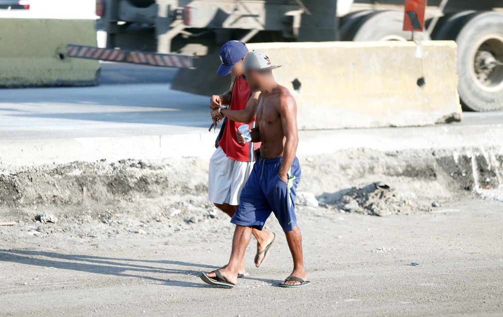 Homem anda com vários celulares na mão em ponto de uso de crack na Avenida Brasil (Foto: Marcos Serra Lima/G1)