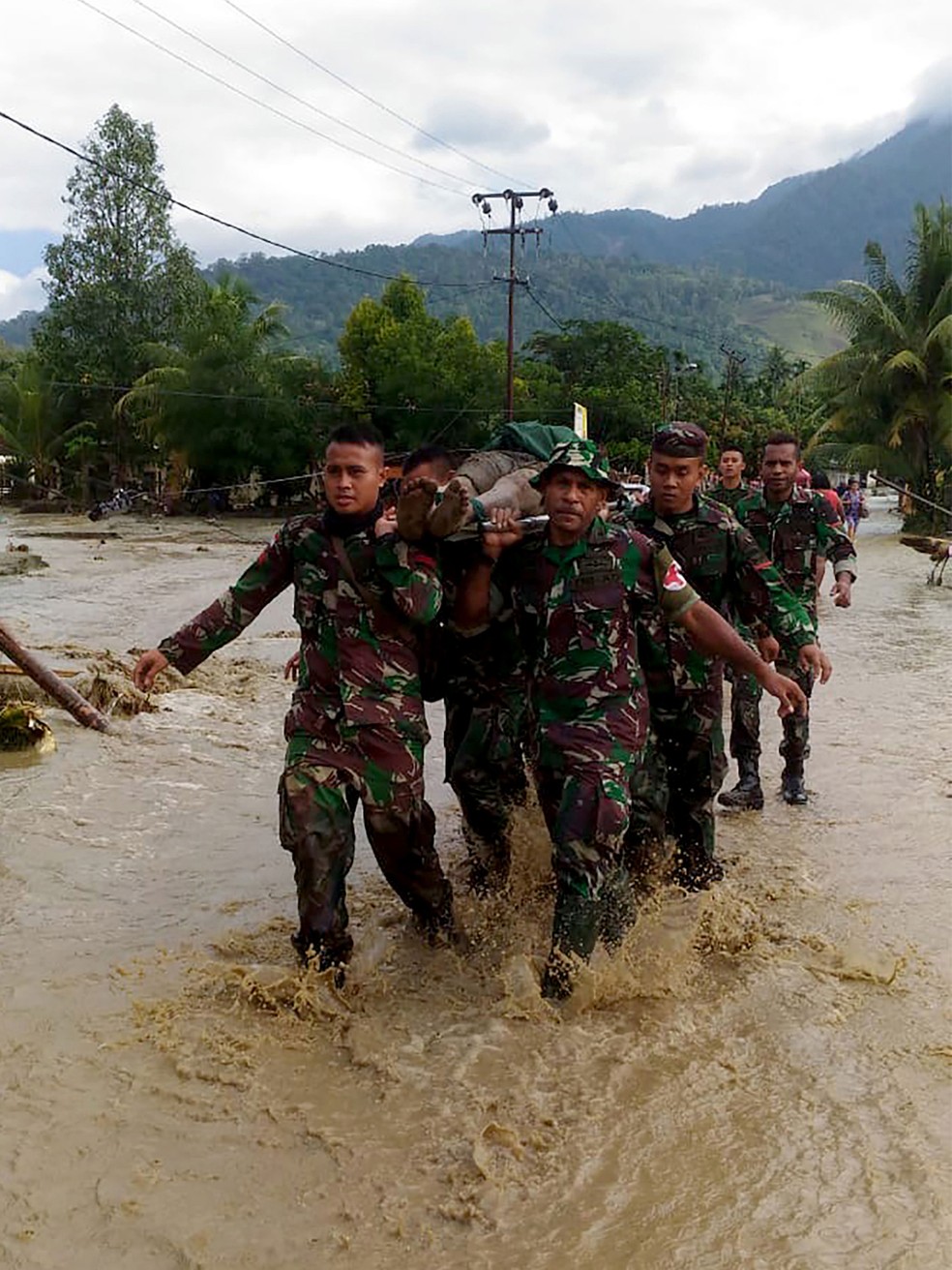 Militares da Indonésia retiram vítima de enchente em Sentani, em Papua, neste domingo (17)  — Foto: Exército da Indonésia / AFP