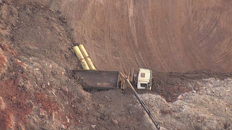 Um caminhão foi soterrado após deslizamento de terra de talude em Sarzedo — Foto: TV Globo