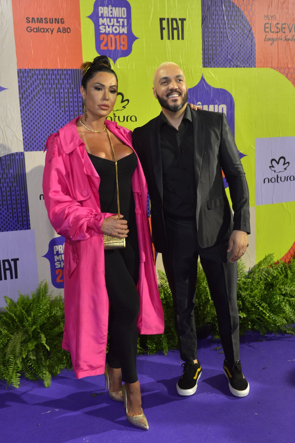 Gracyanne Barbosa foi de macacão justíssimo preto e 'trench coat' rosa chiclete, já Belo investiu em visual total 'black' — Foto: Fabio Cordeiro/Gshow