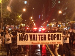 Sob chuva, manifestantes estendem faixa contra a Copa do Mundo (Foto: Daniel Silveira / G1)