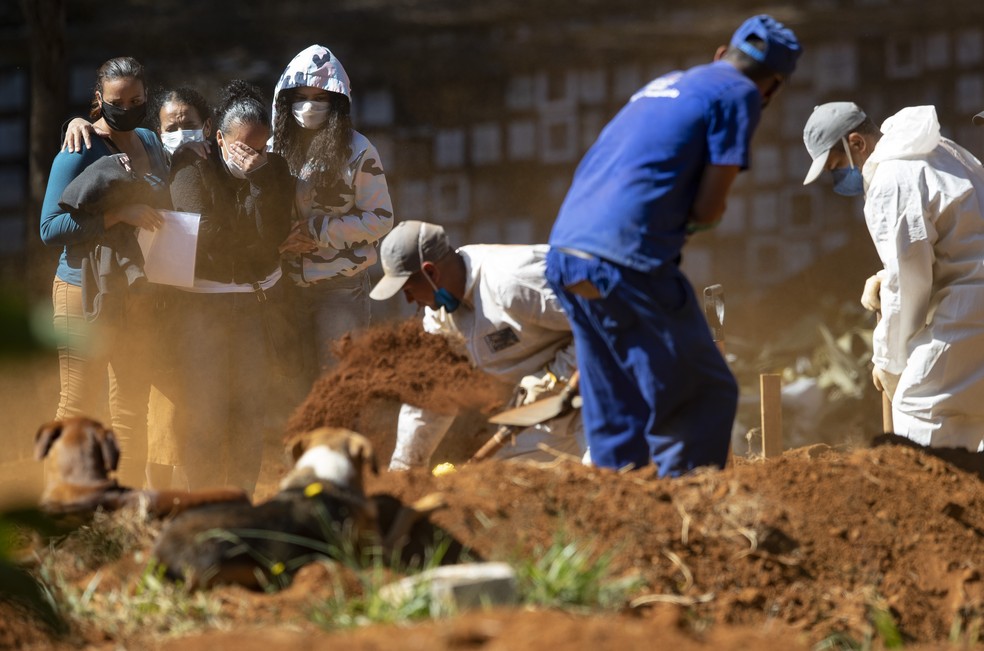 Corpo de Iziquiel Sampaio, vítima do coronavírus, é enterrado no cemitério da Vila Formosa, em São Paulo, nesta quinta-feira (28). — Foto: AP Photo/Andre Penner