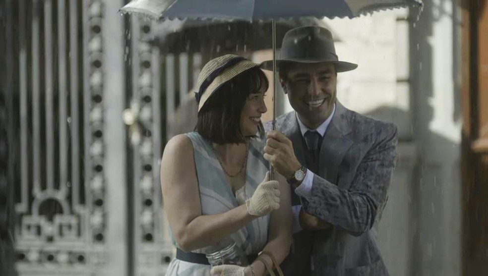Clotilde (Simone Spoladore) e Almeida (Ricardo Pereira) andam juntos na chuva em 'Éramos Seis' — Foto: Globo