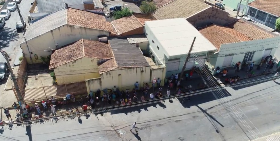 Pessoas carentes formam fila para ganhar ossos doados por açougue de Cuiabá — Foto: TV Centro América