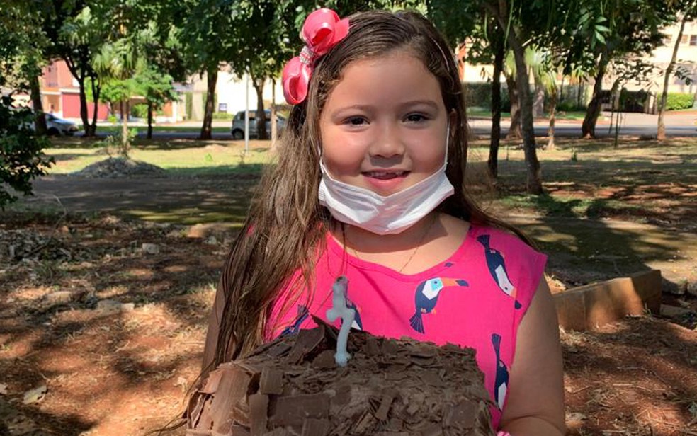 Alicia segura bolo do aniversário de 7 anos dela, em abril de 2020, em Ribeirão Preto, SP — Foto: Arquivo pessoal