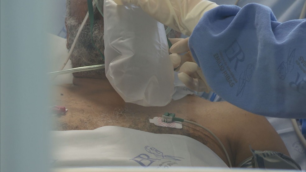 Paciente respirando com balão de oxigênio em hospital do DF. — Foto: TV Globo / Reprodução