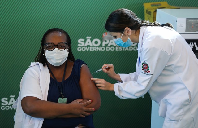 SAO PAULO, BRAZIL - JANUARY 17: Nurse Monica Calazans (54) receives the first CoronaVac vaccination shot in Brazil from Disease Control nurse and Master of Public Health at Santa Casa de Sao Paulo, Jessica Pires de Camargo, at Hospital das Clinicas of the (Foto: Getty Images)