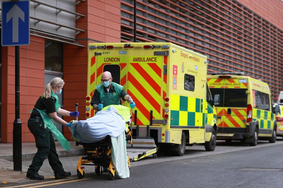 Profissionais de saúde levam paciente a hospital em Londres, no Reino Unido, nesta terça-feira (26) — Foto: Hannah McKay/Reuters