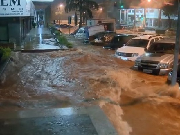 Água quase ultrapassa altura de carros estacionados em quadra comercial da Asa Norte, em Brasília, depois de temporal (Foto: TV Globo/Reprodução)