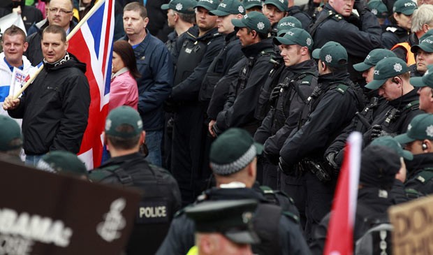 Policiais acompanham manifestação neste sábado (15) em Belfast, na Irlanda do Norte (Foto: Reuters)