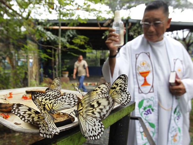 Borboletas são abençoadas pelo padre filipino (Foto: Romeo Ranoco/Reuters)