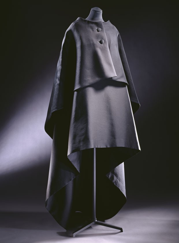 T.39-1974; T.39A-1974Evening gown and cape Gazar, sleeveless dress with scoop neck . Short in the front and dipping to a slight train at the back - this line is echoed by the cape which front fastens with two large self covered buttonsBalenciaga, Paris (Foto:  © Victoria and Albert Museum, London)