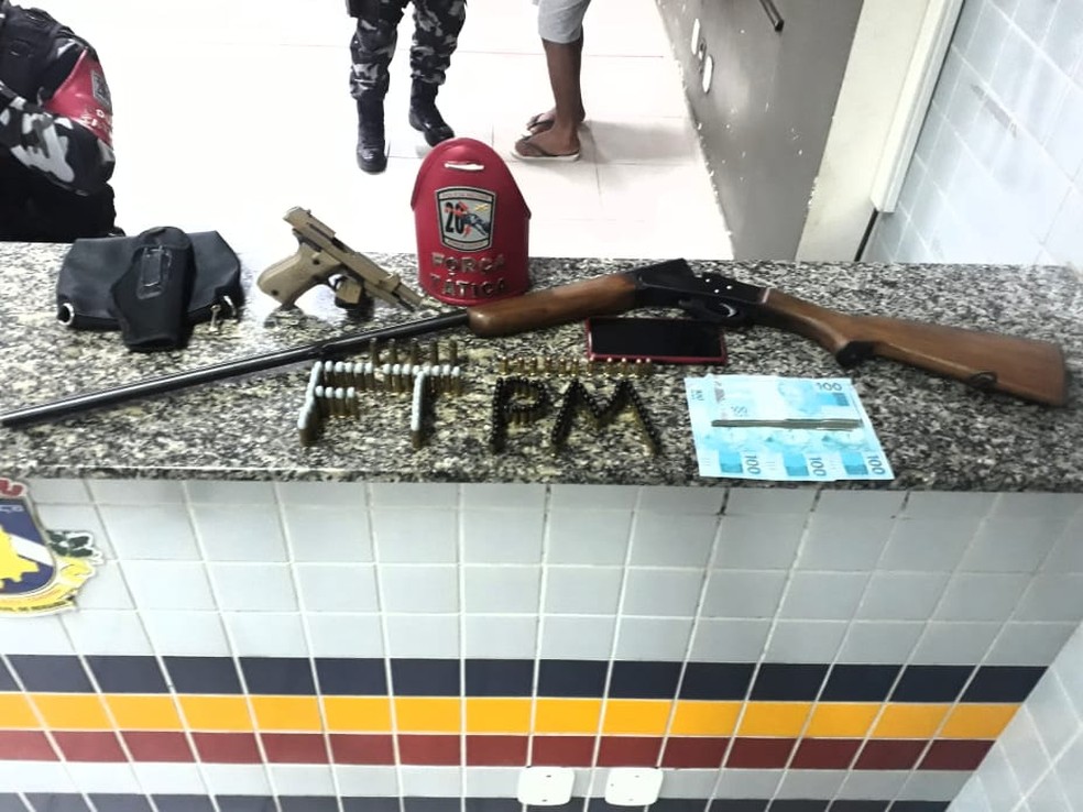 Armas, municões e dinheiro apreendidos com o suspeito — Foto: Polícia Militar/Divulgação