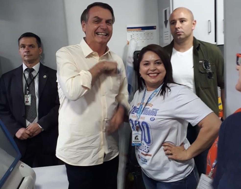 A atendente Adriana Alves ao lado do presidente Jair Bolsonaro que fez aposta na Mega da Virada em uma lotérica do Cruzeiro Velho, em Brasília. — Foto: Arquivo pessoal