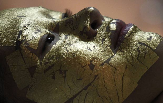 Mulher faz tratamento com máscara facial de ouro. (Foto: Kham/Reuters)