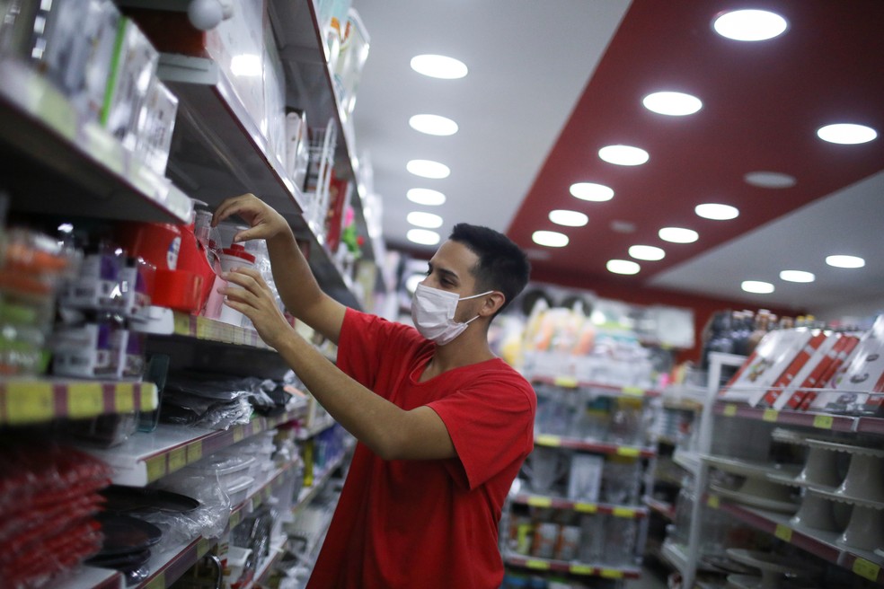 Vendedor com máscara em loja no Rio de Janeiro — Foto: Pilar Olivares/Reuters