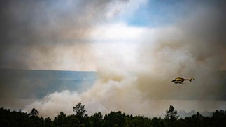 Helicóptero de segurança civil sobrevoa um incêndio florestal em Monts d'Arree, na Bretanha francesa. Onda de calor alimenta incêndios florestais ferozes na Europa  — Foto: LOIC VENANCE / AFP