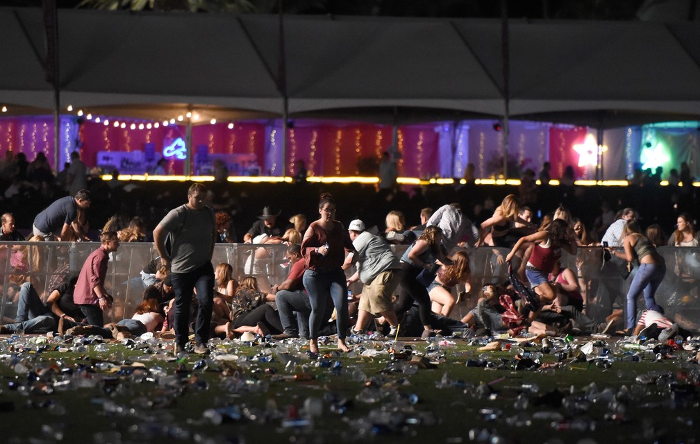Pessoas correm do local do festival de música country após tiros serem disparados em Las Vegas, nos EUA.  (Foto: David Becker/Getty Images/AFP)