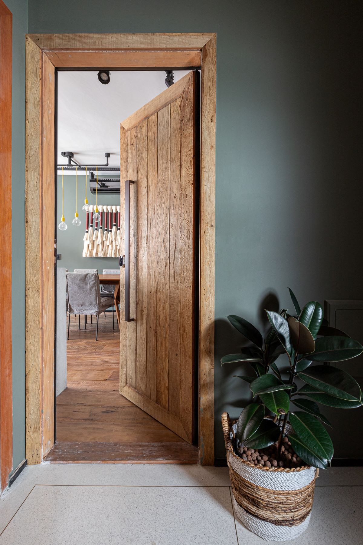 ENTRADA | A porta de madeira e a planta logo na entrada dão o tom do estilo (Foto: Gisele Rampazzo / Divulgação)