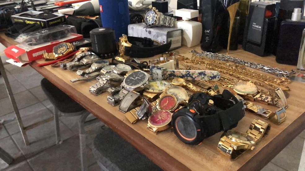 Objetos apreendidos com os suspeitos mortos incluem celulares, relógios e dinheiro.  — Foto: Divulgação: Divisão Especial de Investigação e Capturas (Deic)