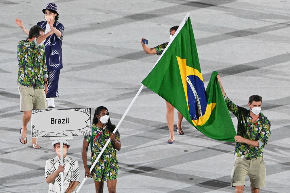 Ketleyn Quadros e Bruno Mossa carregam a bandeira do Brasil durante a cerimônia de abertura dos Jogos Olímpicos de Tóquio, no Japão — Foto: Martin Bureau/AFP