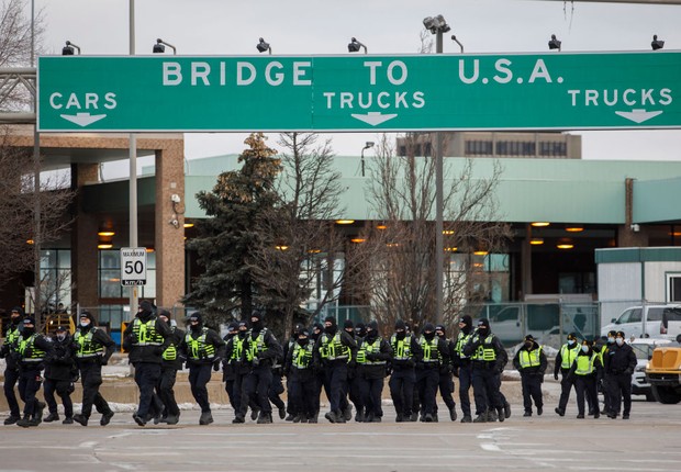 Polícia chega para tirar manifestantes e seus caminhões de um blouqieo na entrada da ponte Ambassador (Foto: Cole Burston/Getty Images)
