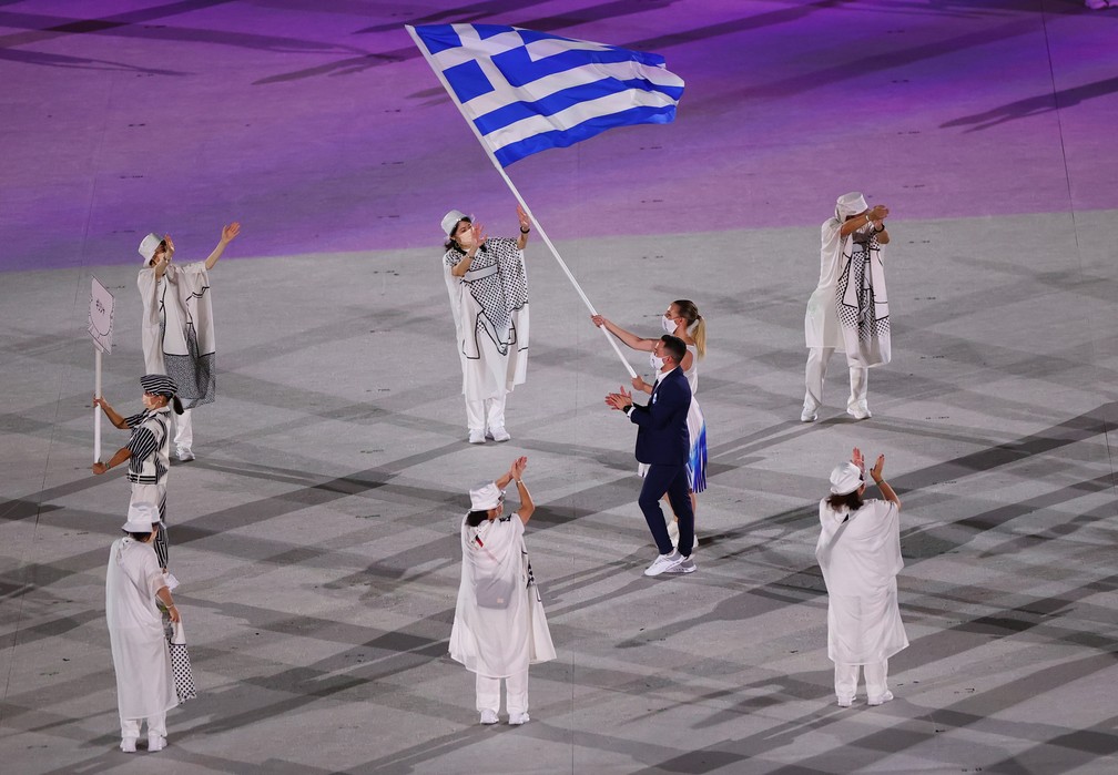  Eleftherios Petrounias e Anna Korakaki carregam a bandeira da Grécia durante a cerimônia de abertura dos Jogos Olímpicos de Tóquio, no Japão — Foto: Marko Djurica/Reuters
