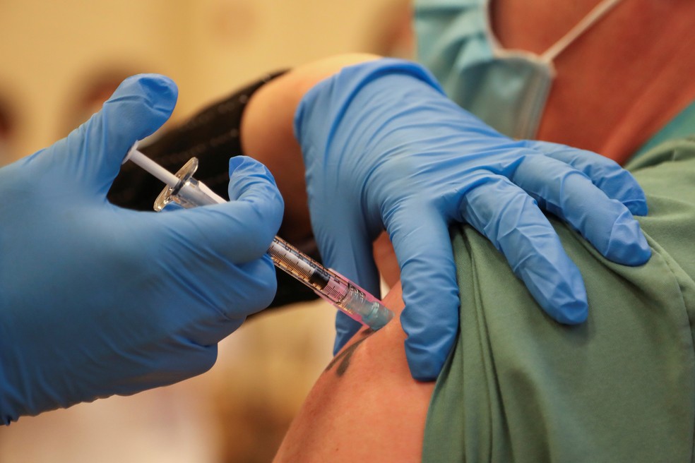 14/12/2020 - Derek Thompson recebeu dose da vacina da Pfizer no The Michener Institute, em Toronto, Ontário, Canadá — Foto: Carlos Osorio/Pool/AFP