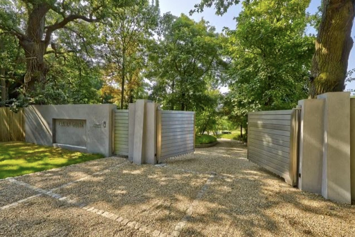 . Paredes de concreto com portões elétricos de madeira cercam os jardins para intensificar a proteção (Foto: CGP DESIGN/ Divulgação)