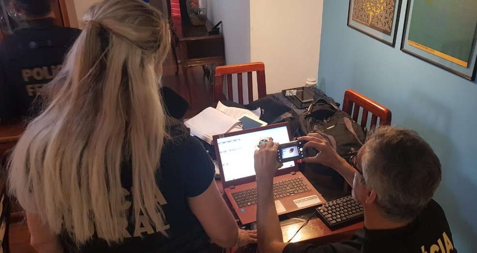 Agentes analisam computador durante 5ª fase da operação Luz na Infância — Foto: Polícia Federal/Divulgação