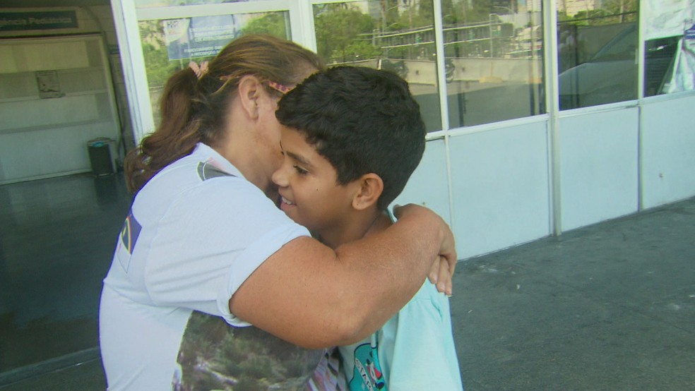 Criança que teve o coração atravessado por espeto recebe carinho da mãe após ter alta de hospital no Recife (Foto: Reprodução/TV Globo)