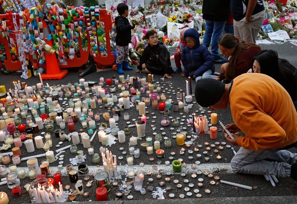Estudantes acendem velas do lado de fora da mesquita Al Noor em Christchurch, na Nova Zelândia, em homenagem às vítimas do tiroteiro  — Foto: Vincent Yu/AP