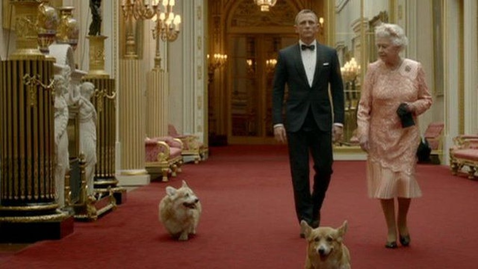 A Rainha Elizabeh, seus corgis e 007 (o ator Daniel Craig) no filme da abertura dos Jogos Olímpicos de 2012 — Foto: Divulgação