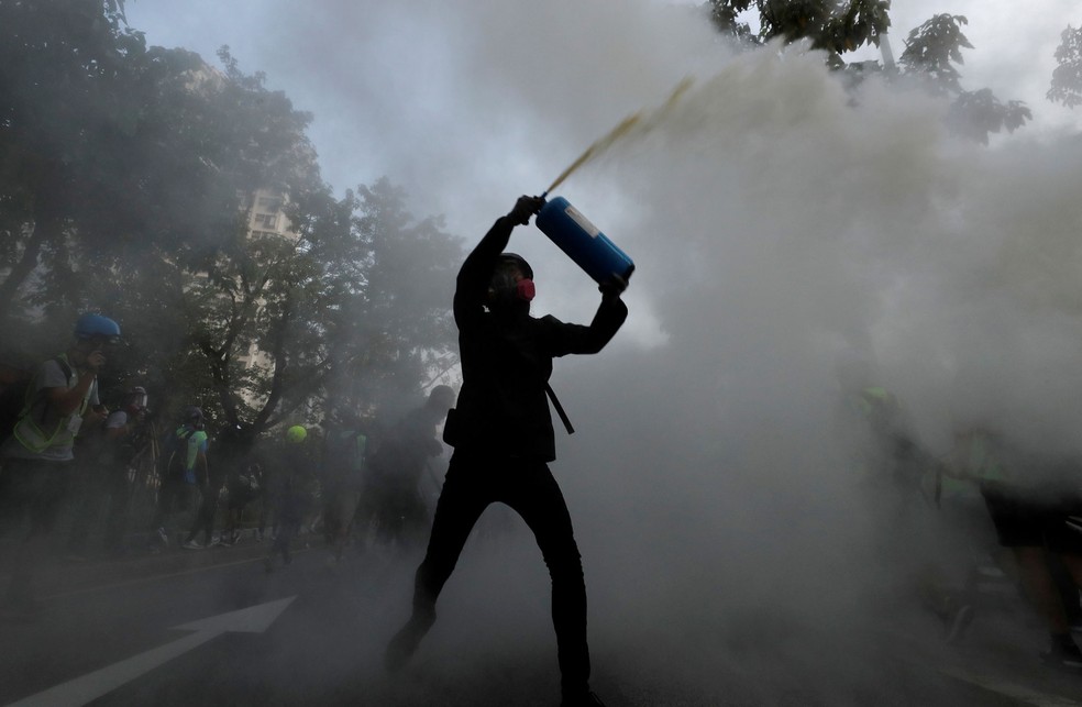 Manifestante usa extintor de incÃªndio durante protestos em Tuen Mun, Hong Kong, neste sÃ¡bado (21) â€” Foto: Tyrone Siu/Reuters