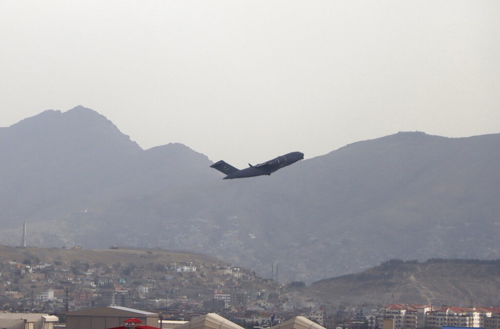 Avião militar dos EUA decola do Aeroporto Internacional Hamid Karzai, em Cabul, na segunda-feira (30), pouco antes do fim do prazo de retirada das tropas do país. — Foto: AP Photo/Wali Sabawoon